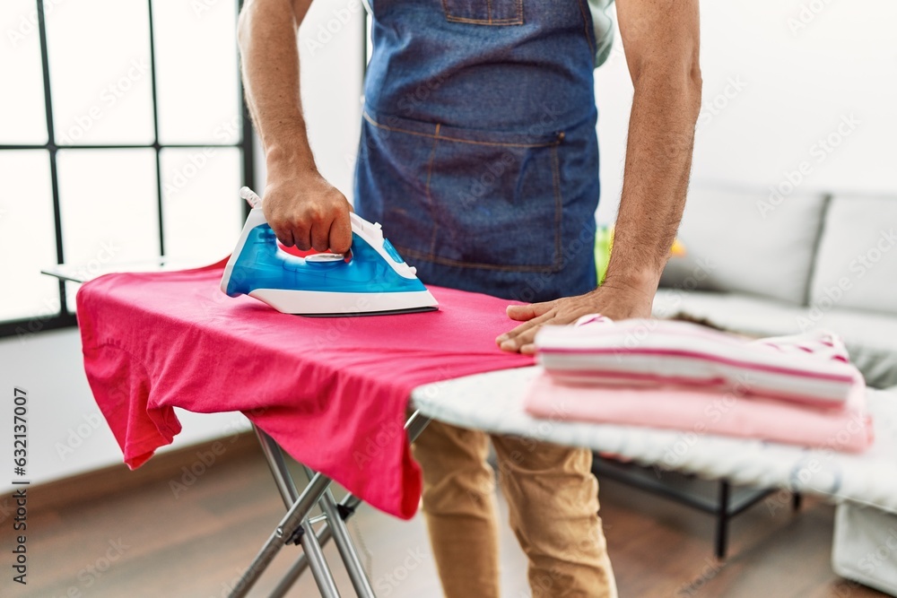 Sticker Middle age grey-haired man ironing clothes at home