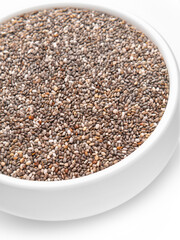 Chia seeds close-up in a white cup, vertical shot. Selective focus.