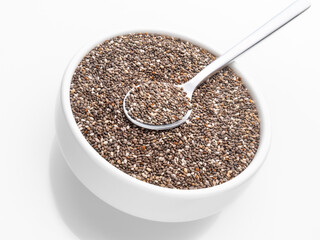 Chia seeds in a white cup on a white background close-up with a spoon. Selective focus.