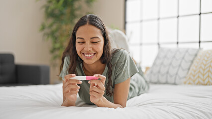 African american woman smiling confident holding pregnancy test at bedroom
