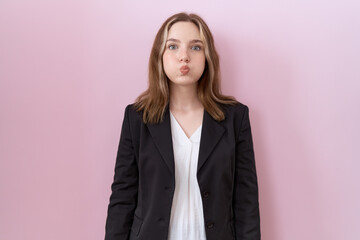 Young caucasian business woman wearing black jacket puffing cheeks with funny face. mouth inflated with air, crazy expression. - obrazy, fototapety, plakaty
