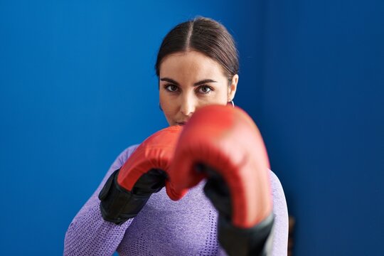 Young beautiful hispanic woman boxing at sport center