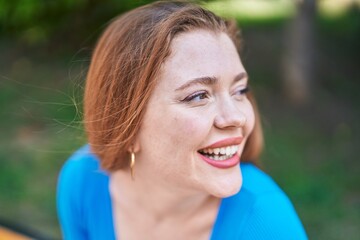 Young redhead woman smiling confident looking to the side at park