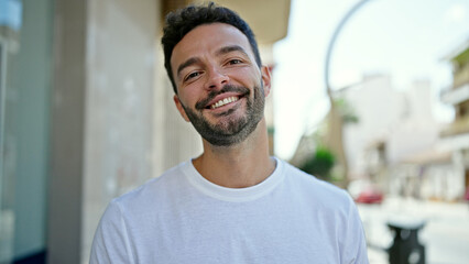 Young hispanic man smiling confident standing at street