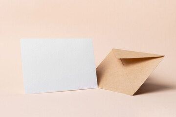 Greeting or invitation card mockup with carft envelope on beige background