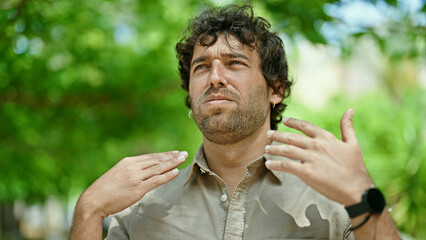 Young hispanic man sweating at park
