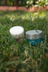 Cosmetics, skin care, beauty concept. White and blue cosmetic jar on green background. Top view. eco friendly. Flat lay.