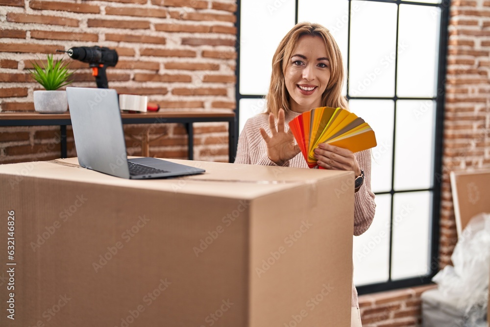 Poster Young woman using laptop choosing paint color at new home