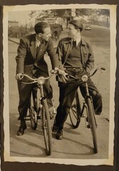 1950er Jahre: zwei junge Männer im Anzug auf dem Fahrrad