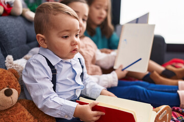 Obraz premium Group of kids drawing on notebook sitting on sofa by christmas decoration at home