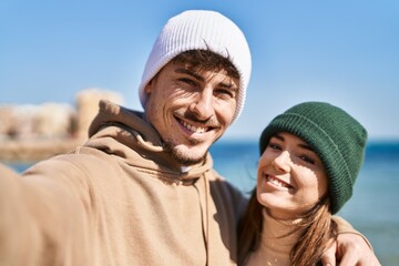 Mand and woman couple hugging each other make selfie by camera at seaside