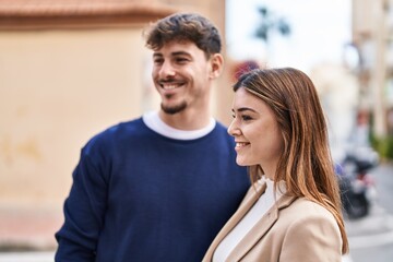 Mand and woman couple smiling confident standing together at street