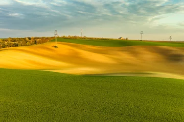 Zelfklevend Fotobehang Green wavy hills with agricultural fields © Kokhanchikov