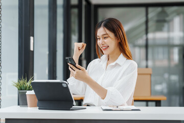 Excited Female secretary business woman in South Korean workplaces, feeling euphoric celebration online win success achievement result rejoicing over good news, raise up hands, good email news