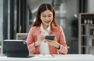 Obraz premium Excited Asian business woman secretary working with product liability, Scarcity, Negotiate, Proposal, Advertising Cost & How to Buy Ads on Any Budget, Interest rate, Dividend, Demand, Remuneration