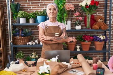 Naklejka na ściany i meble Middle age grey-haired woman florist smiling confident standing with arms crossed gesture at florist
