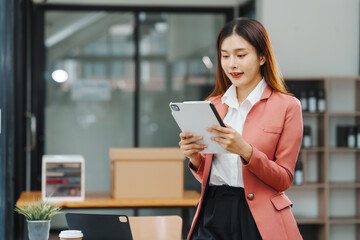 Using tablet, pc of Excited Asian business woman secretary working with product liability, Scarcity, Negotiate, Proposal, Advertising Cost & How to Buy Ads on Any Budget, Interest rate, Dividend