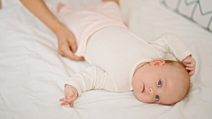 Mother and daughter wearing pyjama lying on bed at bedroom