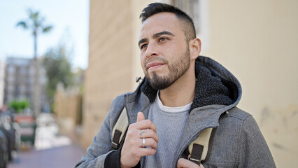 Hispanic man smiling confident looking to the side at street