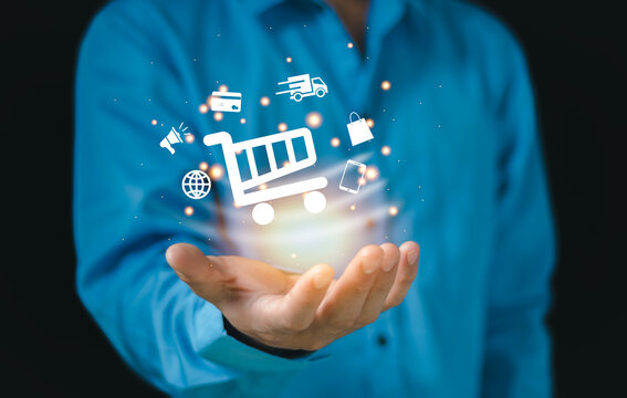 businessperson Hand holding virtual shopping cart icons , Technology online shopping business delivery e-commerce concept.vnm,.