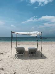 Empty sun beds on the beach. The tropical vibe, island life, exotic vacation. Indonesia Bali. Beach resort. 