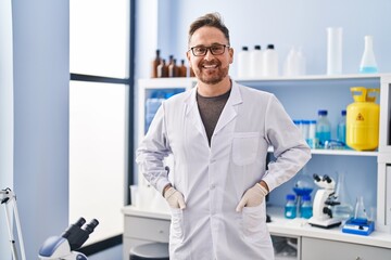 Naklejka na ściany i meble Young caucasian man scientist smiling confident standing at laboratory