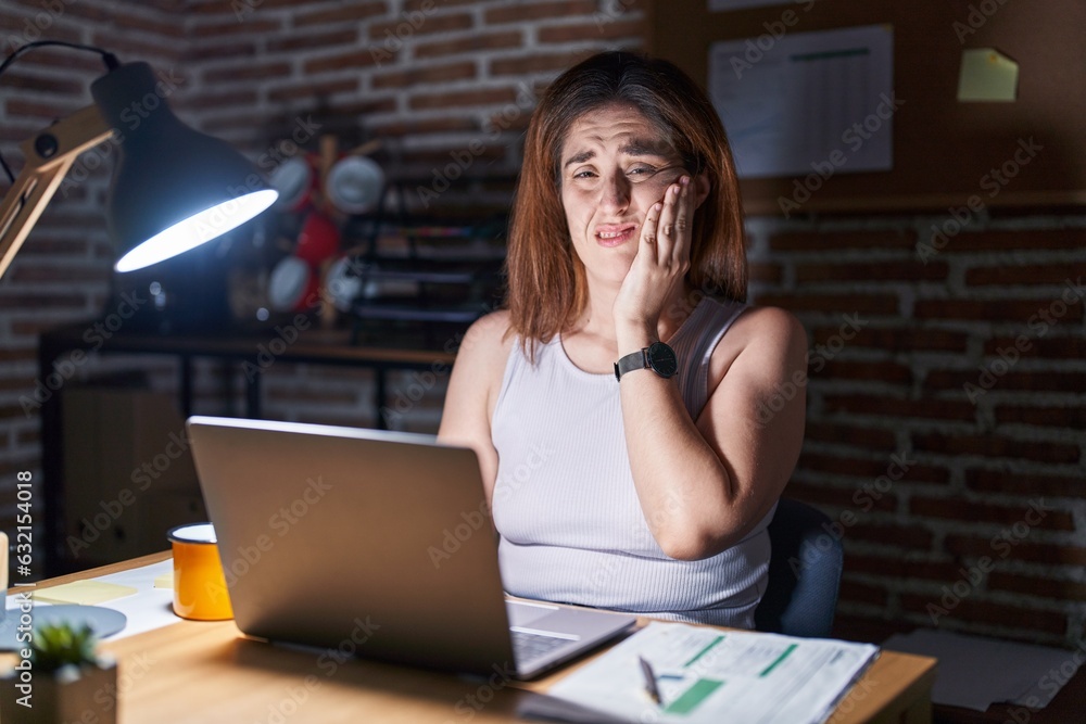 Wall mural Brunette woman working at the office at night touching mouth with hand with painful expression because of toothache or dental illness on teeth. dentist