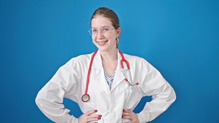 Young blonde woman doctor smiling confident saying yes with head over isolated blue background