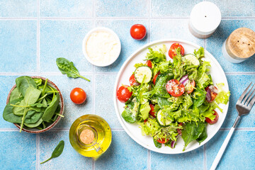 Green vegetable salad with fresh leaves on white plate. Healthy food, diet menu. Top view with space for text.