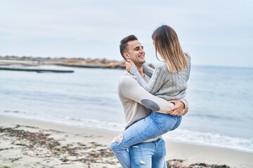 Man and woman couple hugging each other holding on arms at seaside