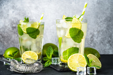 Mojito with rum, lime, mint and ice on black background. Tradition Summer drink.