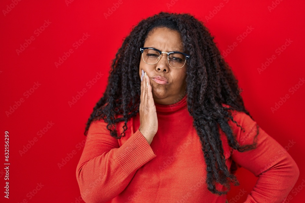 Sticker Plus size hispanic woman standing over red background touching mouth with hand with painful expression because of toothache or dental illness on teeth. dentist