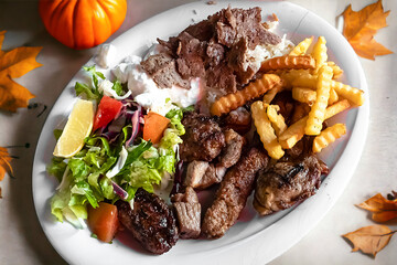 Hearty, diet food. Lamb skewers, fresh vegetables and french fries. Ready menu for a restaurant.