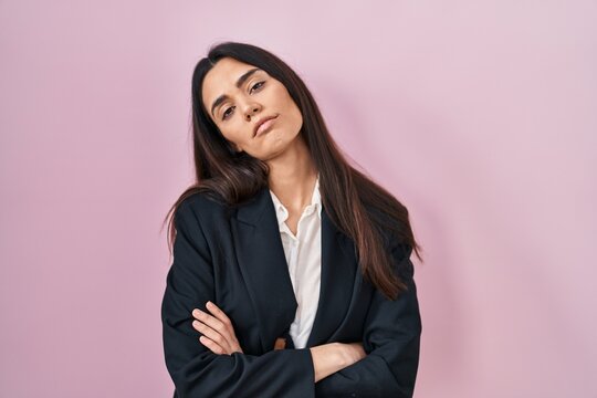 Young brunette woman wearing business style over pink background looking sleepy and tired, exhausted for fatigue and hangover, lazy eyes in the morning.