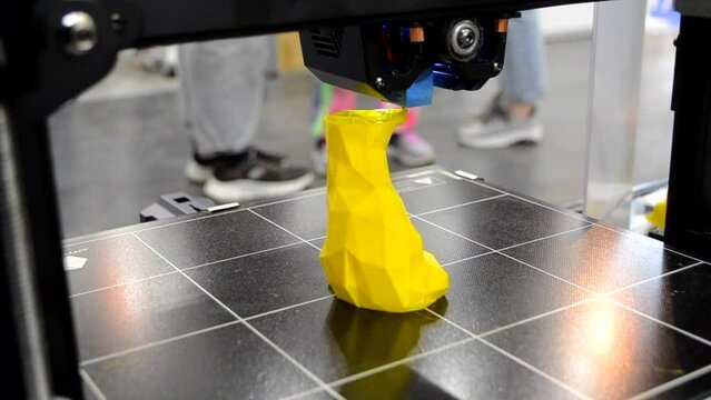 Working 3D printer printing an object from plastic. Printing a model from molten plastic using a 3D printer. Creation of a form by a 3D printer. Additive progressive new modern 3d printer technology