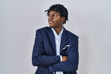Young african man with dreadlocks wearing business jacket over white background looking to the side with arms crossed convinced and confident