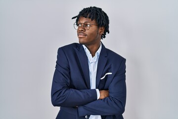 Young african man with dreadlocks wearing business jacket over white background looking to the side...