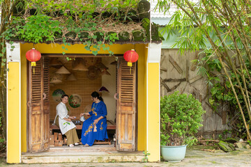 Fototapeta na wymiar Portrait of Asian and Caucasian woman in Ao Dai Dress in the garden 