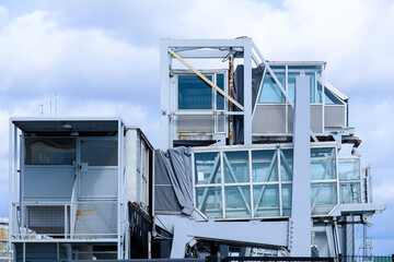 View on an elevated passenger skywalk at the cruise ship terminal against a cloudy sky.