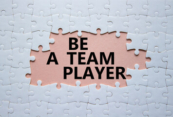 Be a team player symbol. Concept words Be a team player on white puzzle. Beautiful pink background. Business and Be a team player concept. Copy space