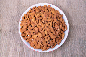 Top view of A Bowl almonds on the brown fabric