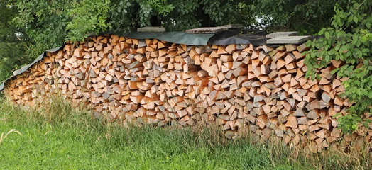 Foto op Aluminium stacked dry firewood as a background © maho