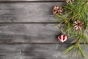Christmas wooden background with Christmas tree, pinecones and toy. Minimalism. Mockup. Copy space.