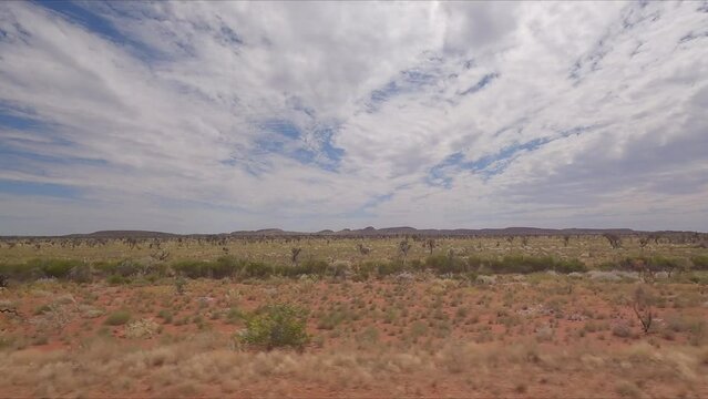 Traveling along Western Australian coastal highway past shrubs and low mountain ranges