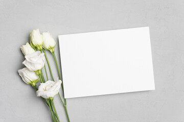 Fototapeta na wymiar Blank wedding invitation card mockup with white eustoma flowers