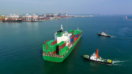 Poster  rear view of cargo container ship and tugboat sailing in sea and commercial port background to import export goods and distributing products to dealer and consumers worldwide, by container ship t  © SHUTTER DIN