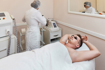Obraz premium young man undergoes procedure of arm pit laser epilation