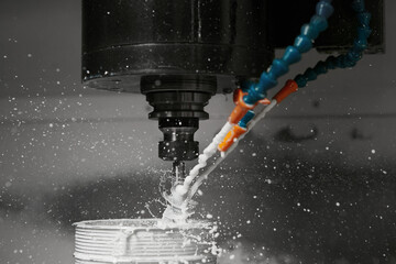 CNC milling machine cutting aluminium automotive part with a coolant liquid. Hi-Technology...