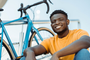 Smiling african american man looking at camera while resting near his bike
