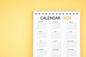 The 12 months desk calendar 2024 on yellow background.